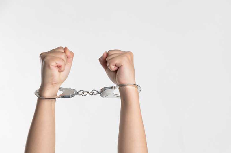 two hands in hand cuffs